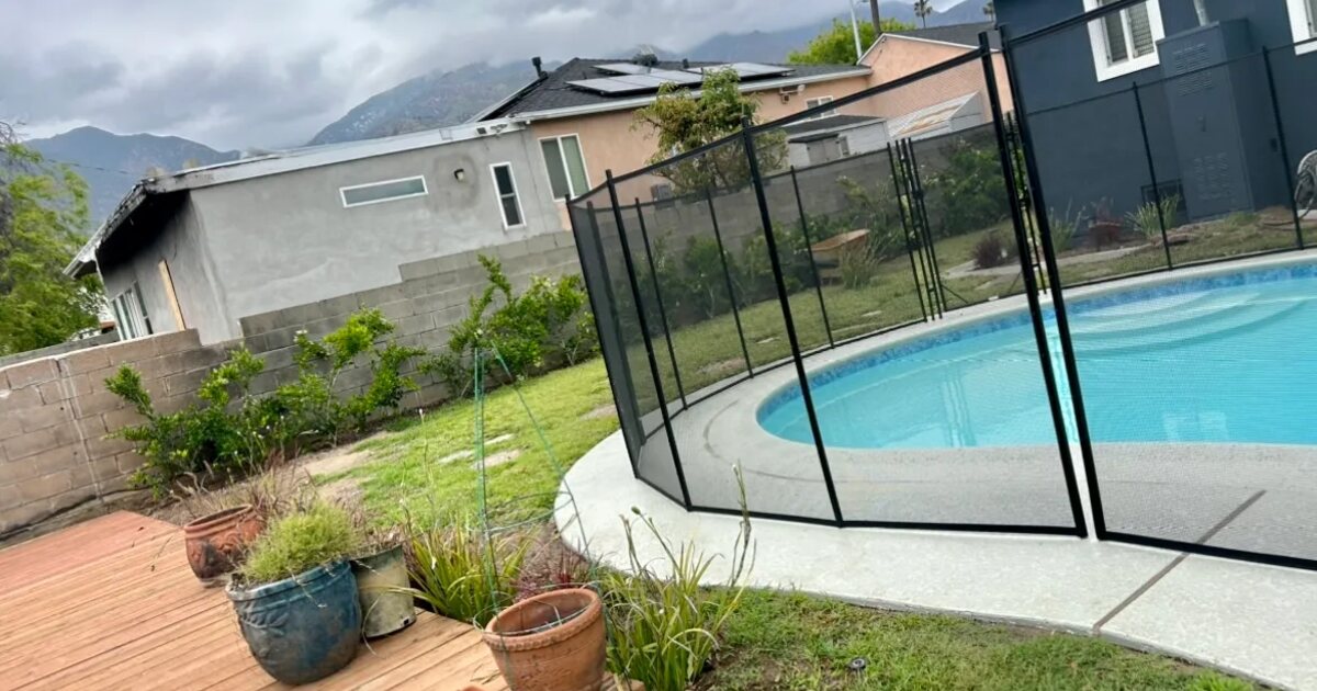 Restored pool area with new safety fence and landscaping on a fire-rebuilt Altadena property