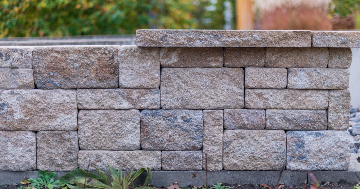 Stone block retaining wall with landscaping plants