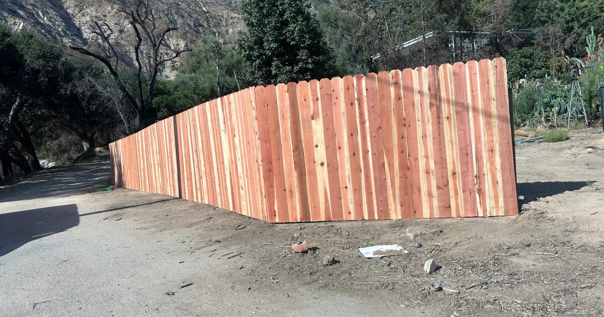 Newly installed redwood privacy fence with the San Gabriel Mountains behind it