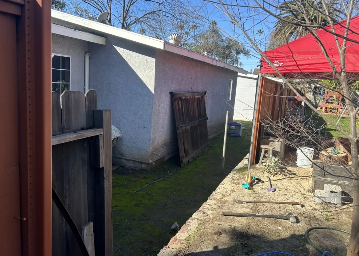 Backyard gate area with patchy grass before renovation