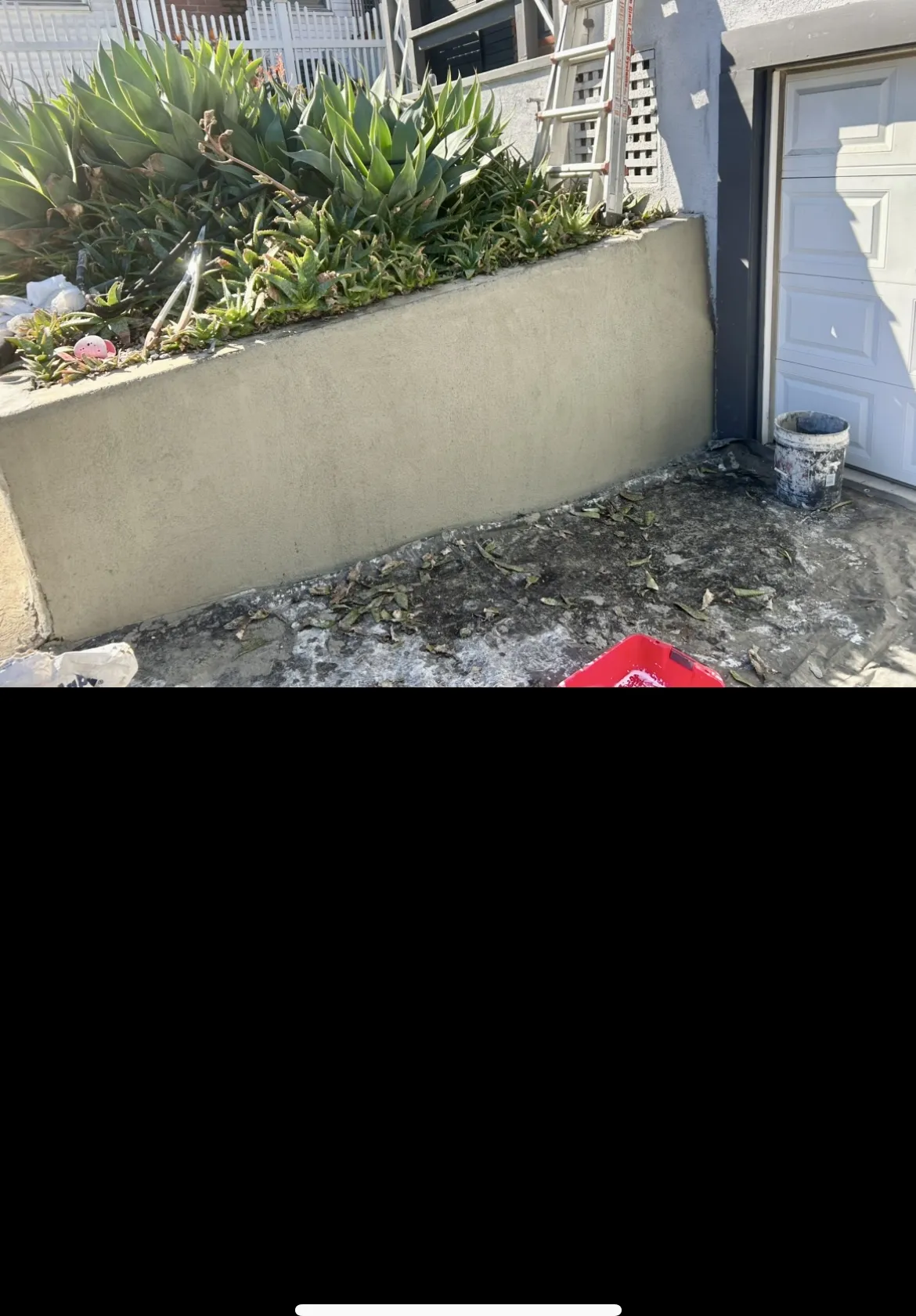Concrete planter near garage before backyard renovation