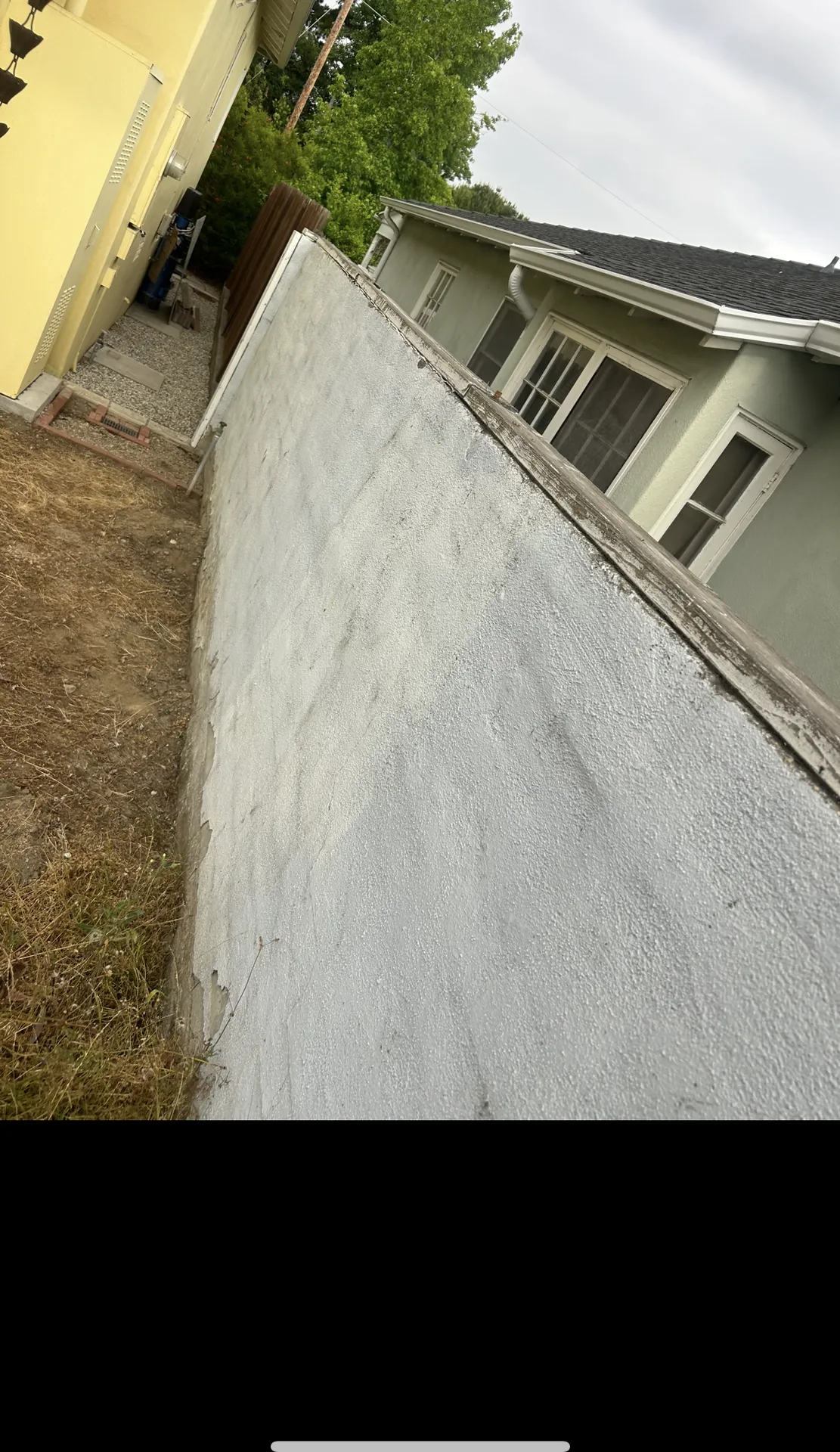 Freshly painted white stucco retaining wall