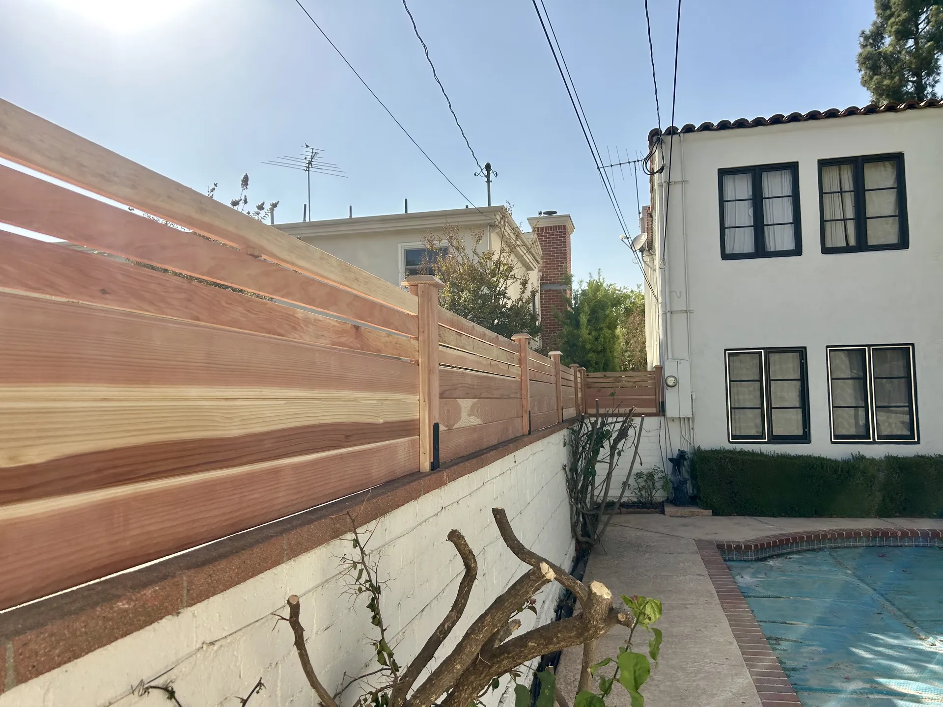 Close-up detail of horizontal cedar fence topper on block wall
