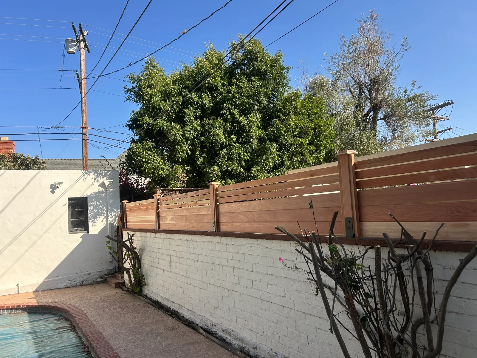 New horizontal redwood fence topper on pool area