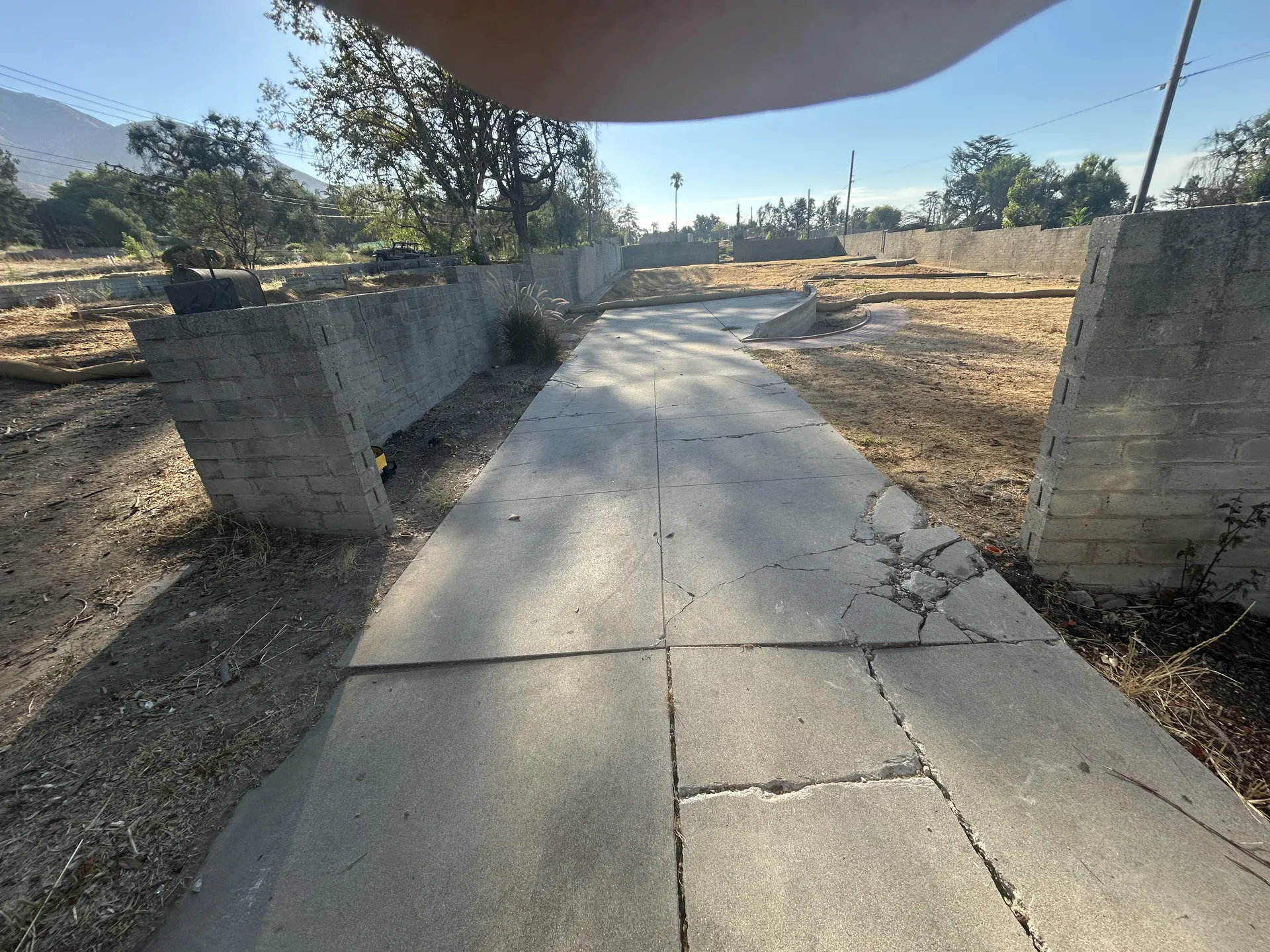 Cracked walkway and block walls before fence project