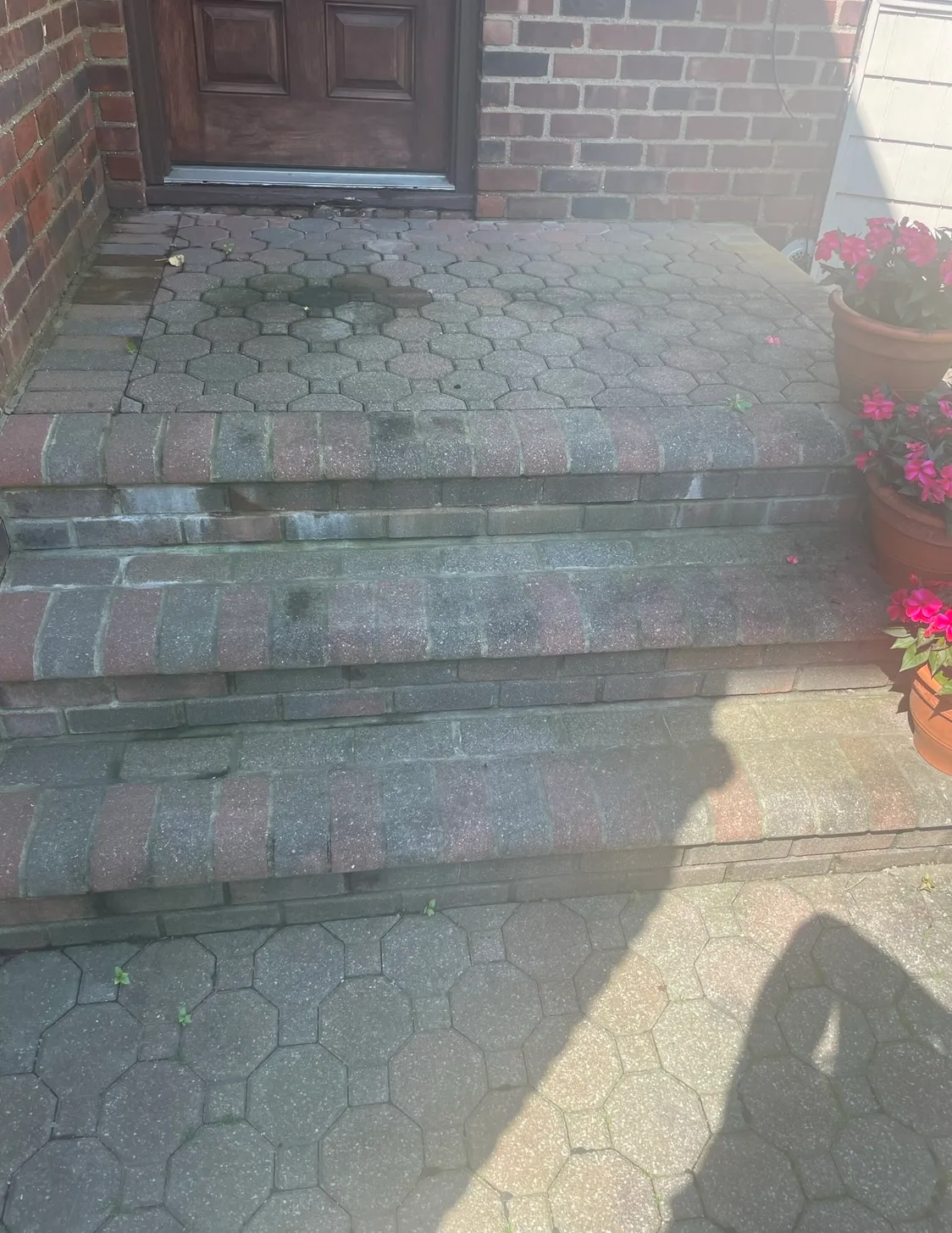 Faded and discolored brick porch steps before cleaning