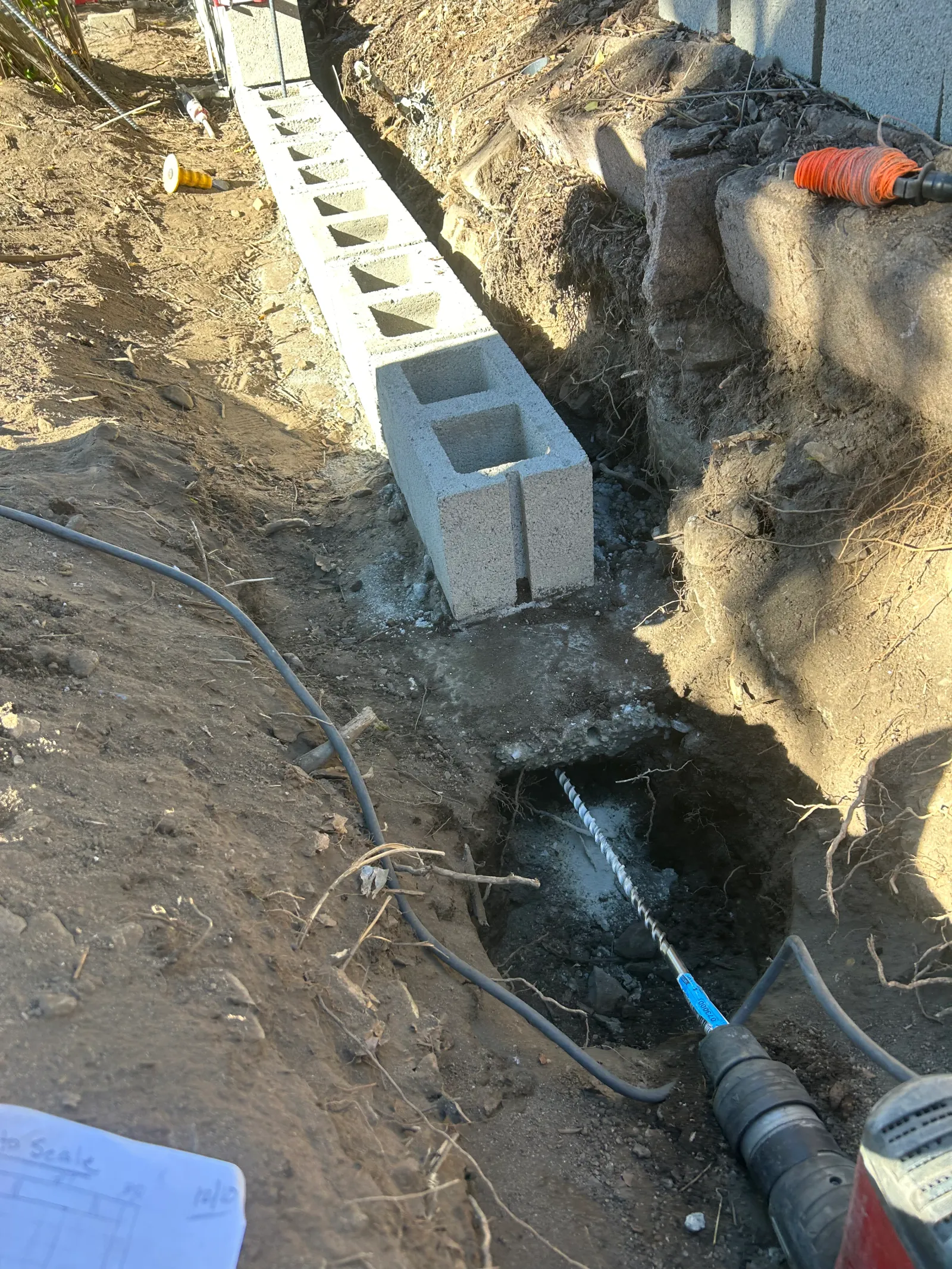Cinder block footing being set for retaining wall