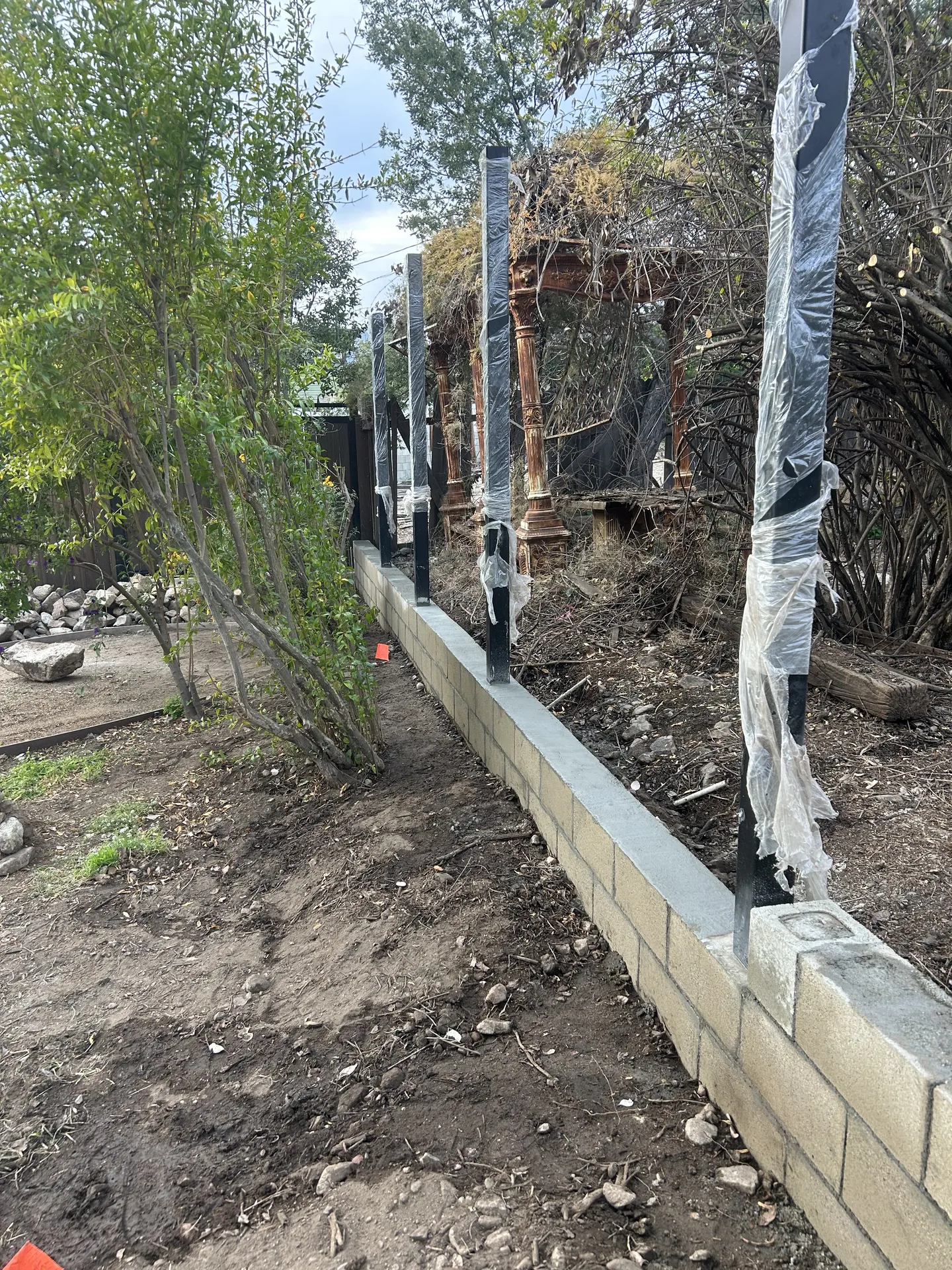 Waterproofing and bracket installation on retaining wall